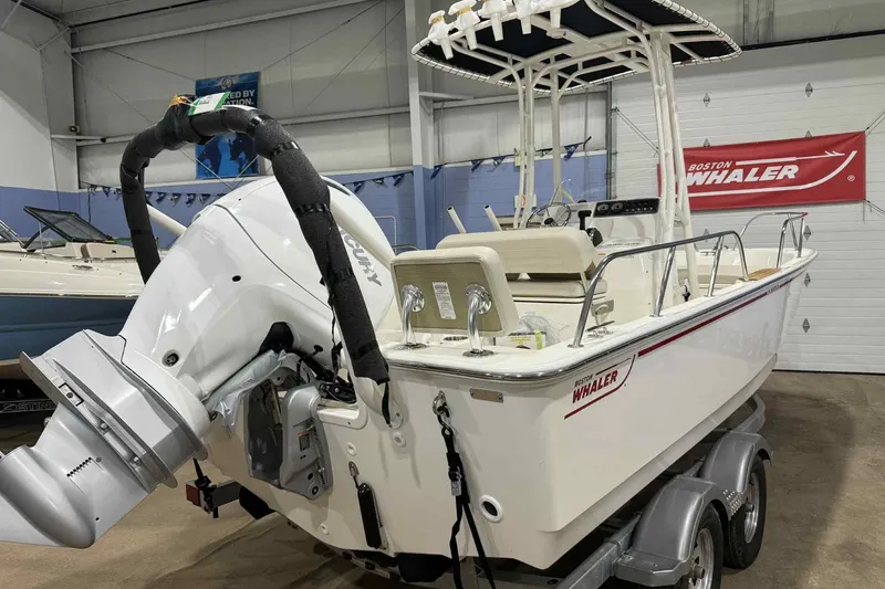 Slide: The Image of 2026 Boston Whaler 190 Montauk boat with outboard motor in showroom. - 2