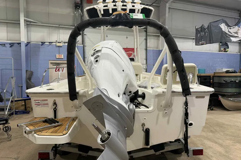 Slide: The Image of 2026 Boston Whaler 190 Montauk boat in a garage, rear view with motor and swim platform. - 3