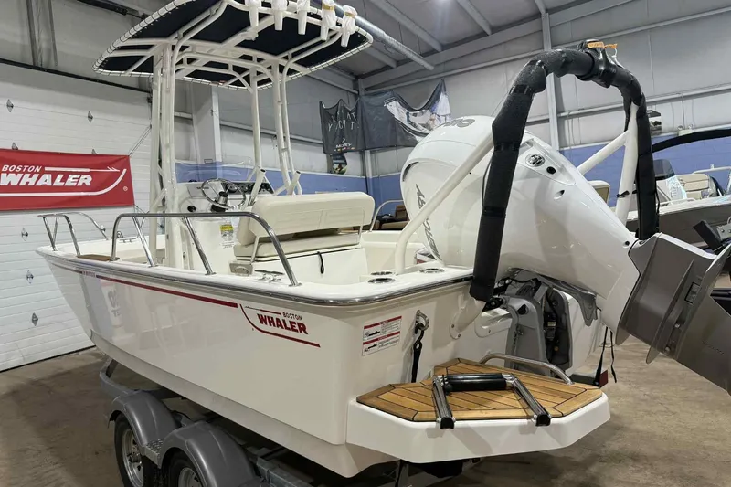 Slide: The Image of 2026 Boston Whaler 190 Montauk boat in showroom, featuring outboard motor and trailer. - 4