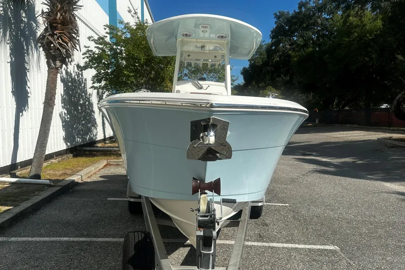 Slide: The Image of 2022 Cobia 262 Center Console boat on trailer, parked outdoors under clear sky. - 2