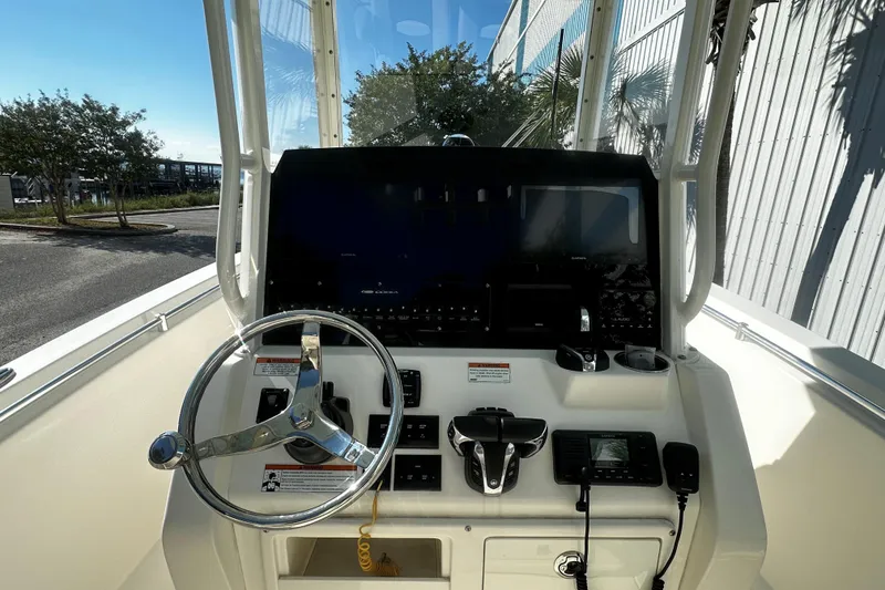 Slide: The Image of 2022 Cobia 262 Center Console boat dashboard with steering wheel and navigation controls. - 6