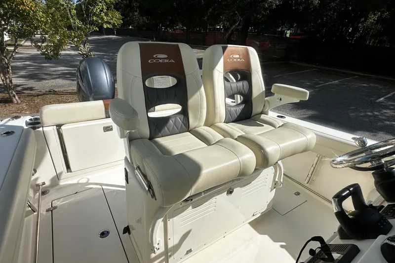 Slide: The Image of 2022 Cobia 262 Center Console boat with dual cushioned seats and steering wheel. - 7