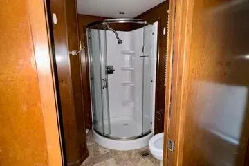 Slide: The Image of 2013 Bravada Bella Luna bathroom with circular shower and wooden cabinetry. - 13