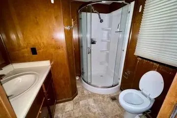 Slide: The Image of 2013 Bravada Bella Luna bathroom with shower, sink, and toilet in a compact layout. - 14