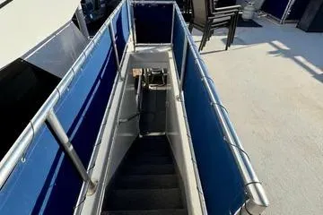 Slide: The Image of Staircase on 2013 Bravada Bella Luna boat with blue railings and outdoor seating. - 21