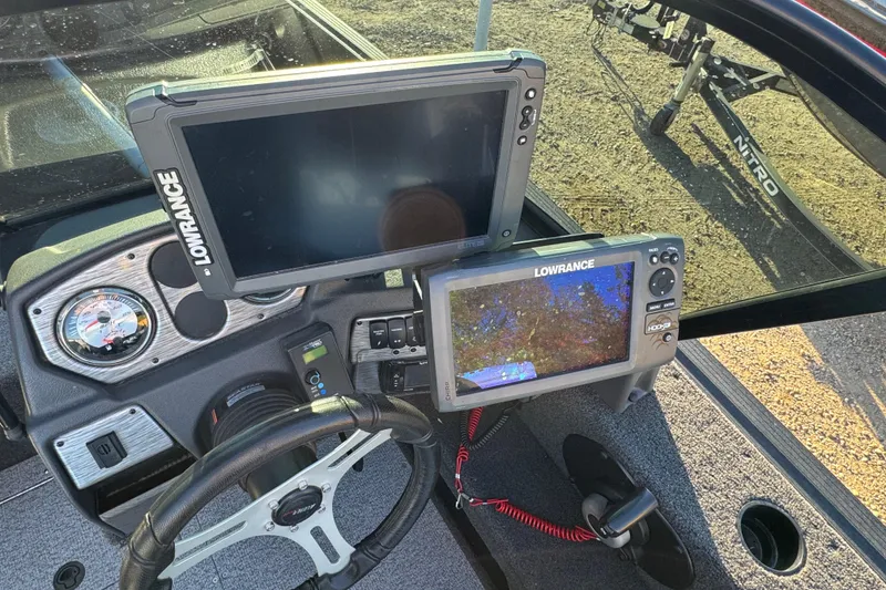 Slide: The Image of 2017 Alumacraft Competitor 205 Sport dashboard with Lowrance fish finders and steering wheel. - 10
