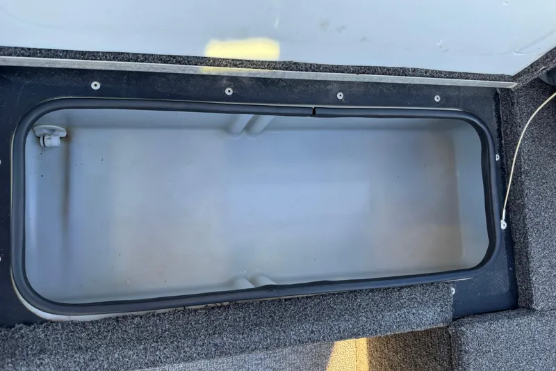 Slide: The Image of 2017 Alumacraft Competitor 205 Sport storage compartment, open and empty, with carpeted edges. - 13