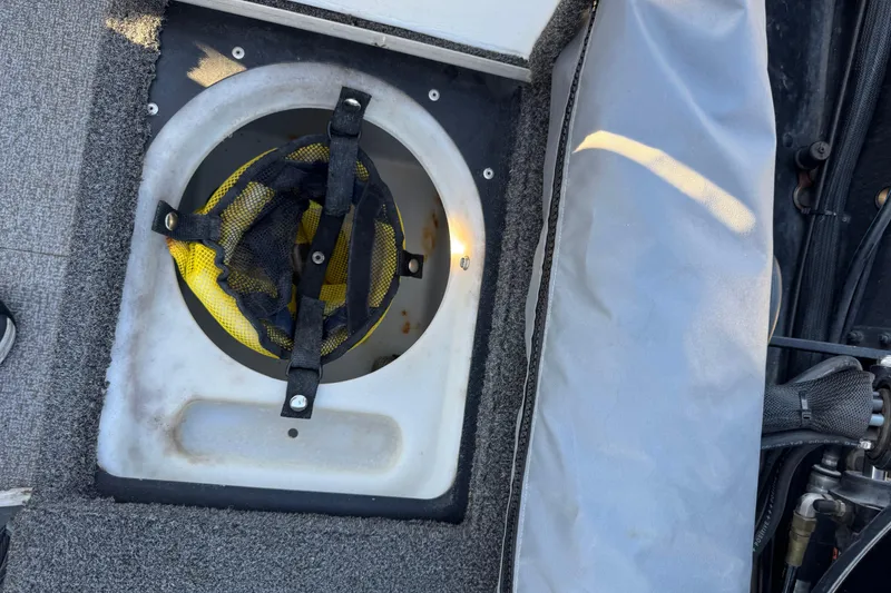 Slide: The Image of 2017 Alumacraft Competitor 205 Sport boat compartment with yellow mesh storage bag. - 14