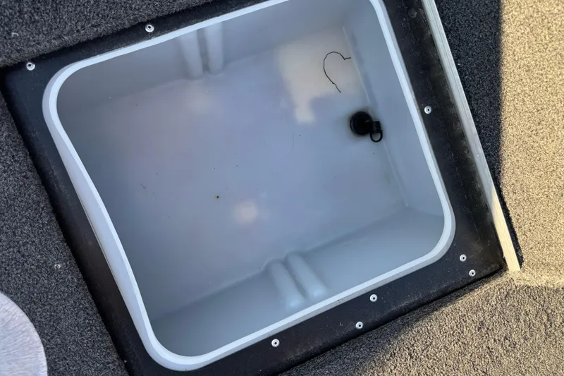 Slide: The Image of 2017 Alumacraft Competitor 205 Sport storage compartment, open and empty, with carpeted edges. - 21