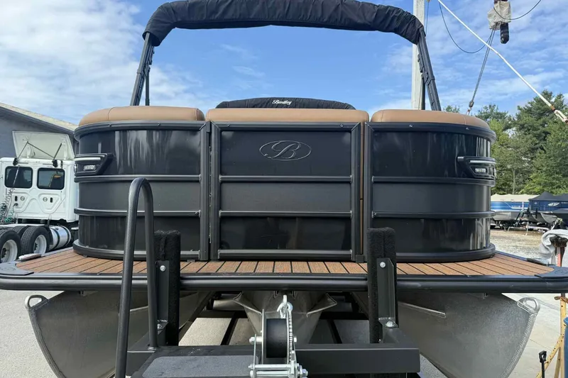 Slide: The Image of 2025 Bentley Pontoons Elite 253 Admiral, black exterior, docked on trailer, sunny day. - 7