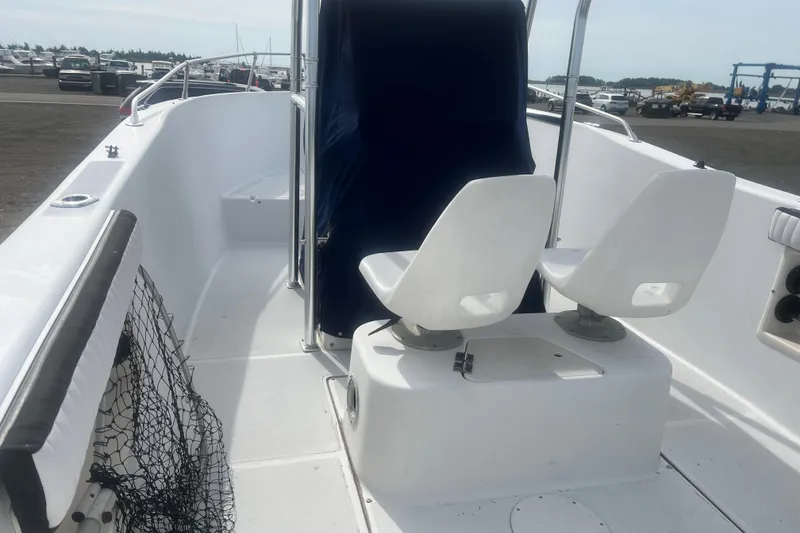 Slide: The Image of 2000 Seaswirl Striper 18.5 boat interior with dual white seats and fishing net. - 12
