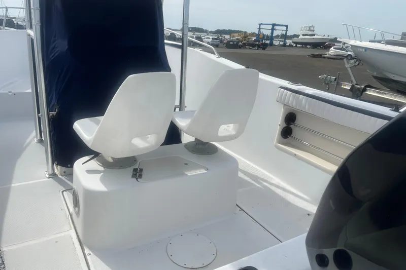 Slide: The Image of 2000 Sea Swirl 18.5 boat interior with white swivel seats and storage compartments. - 3