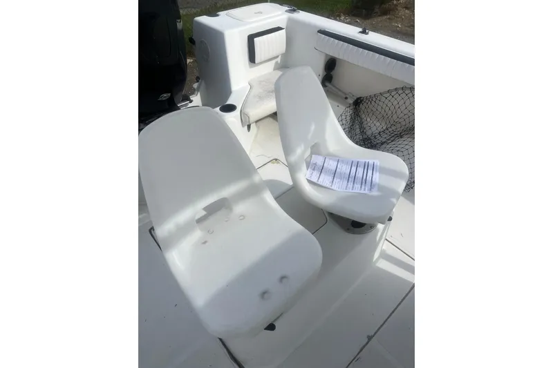 Slide: The Image of Interior of 2000 Sea Swirl 18.5 boat with white seating and netting. - 7