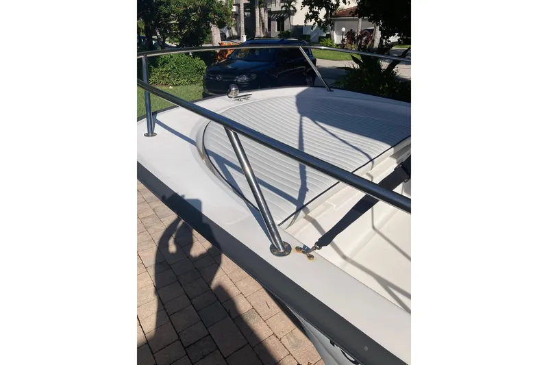 Slide: The Image of 2006 Boston Whaler 150 Sport boat deck with railing, parked on a sunny driveway. - 10