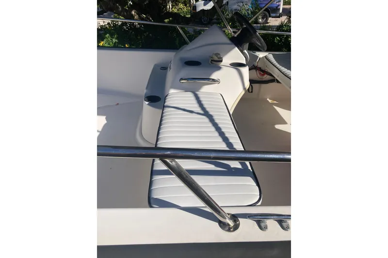 Slide: The Image of 2006 Boston Whaler 150 Sport boat interior with white seating and steering console. - 11