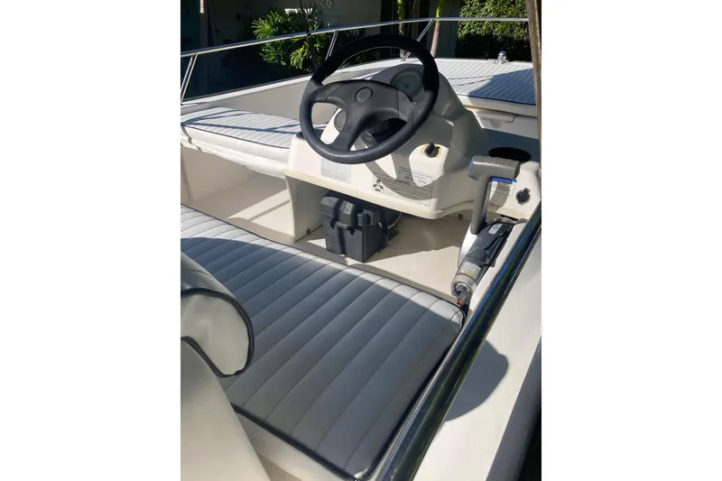 Slide: The Image of 2006 Boston Whaler 150 Sport boat interior with steering wheel and seating. - 12
