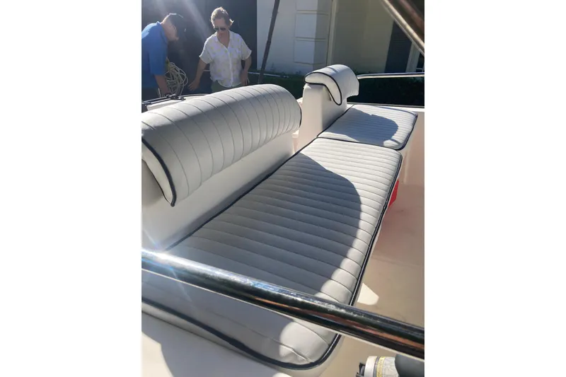 Slide: The Image of 2006 Boston Whaler 150 Sport boat interior with white cushioned seating. - 13