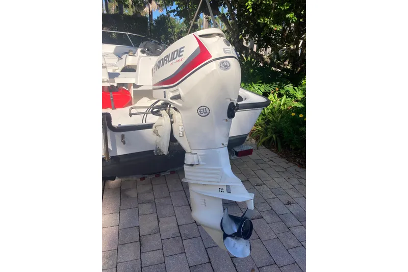 Slide: The Image of 2006 Boston Whaler 150 Sport with Evinrude E-TEC outboard motor on paved driveway. - 4