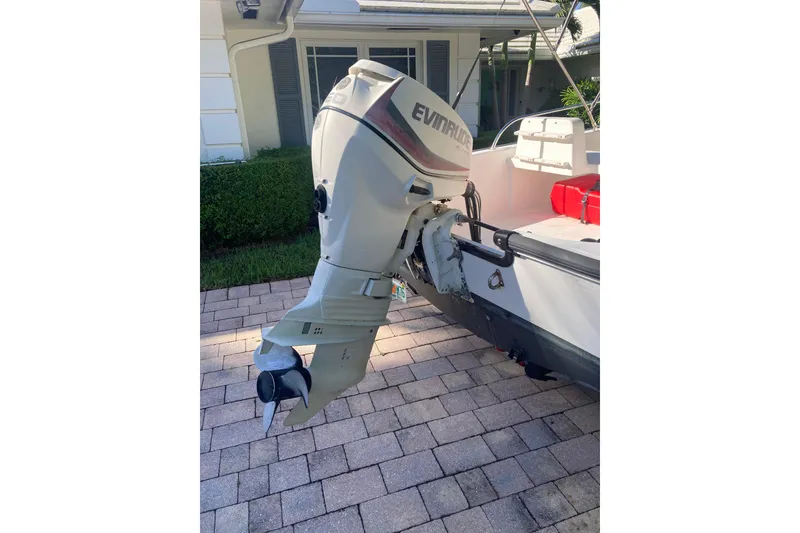 Slide: The Image of 2006 Boston Whaler 150 Sport with Evinrude outboard motor on a paved driveway. - 6