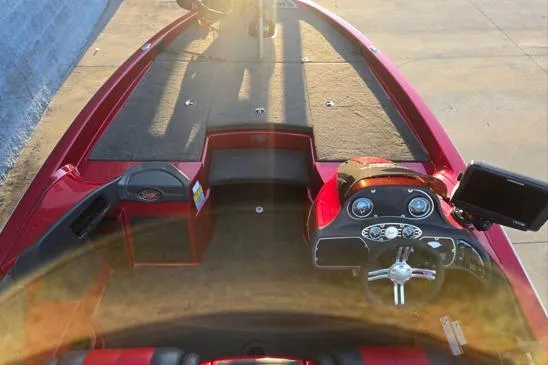 Slide: The Image of 2011 Ranger Z120 Comanche boat interior with red and black seats, steering wheel, and storage compartments. - 11