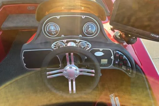 Slide: The Image of Dashboard of a 2011 Ranger Z120 Comanche boat with steering wheel and navigation system. - 12