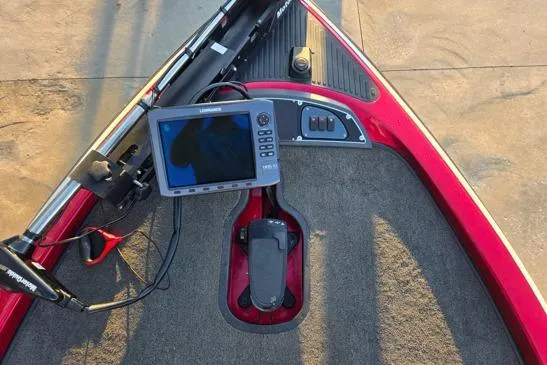 Slide: The Image of 2011 Ranger Z120 Comanche fishing boat on trailer, red and black design, parked outdoors. - 7