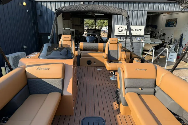 Slide: The Image of 2025 Bentley Pontoons Elite 253 Swingback with luxurious tan seating and sleek design. - 11