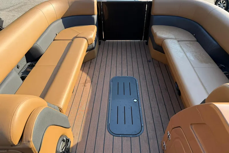 Slide: The Image of 2025 Bentley Pontoons Elite 253 Swingback interior with tan seating and wood-style flooring. - 13