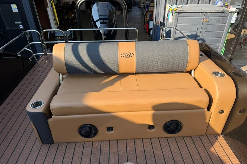 Slide: The Image of 2025 Bentley Pontoons Elite 253 Swingback with tan seating and cup holders. - 14