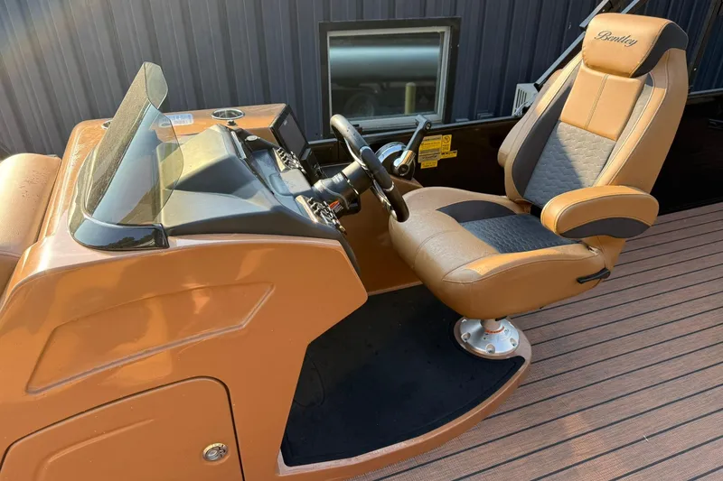 Slide: The Image of 2025 Bentley Pontoons Elite 253 Swingback helm with luxurious captain's chair and controls. - 15