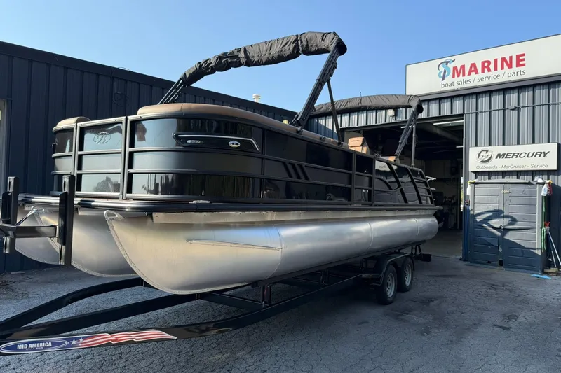 Slide: The Image of 2025 Bentley Pontoons Elite 253 Swingback at a marine dealership. - 2