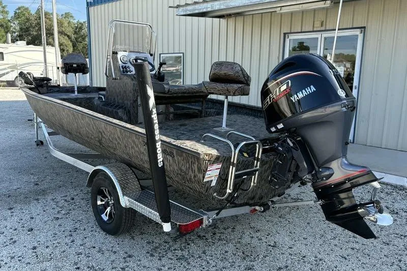 Slide: The Image of 2026 Xpress H20B Bay boat with Yamaha engine on trailer, parked outside a building. - 10