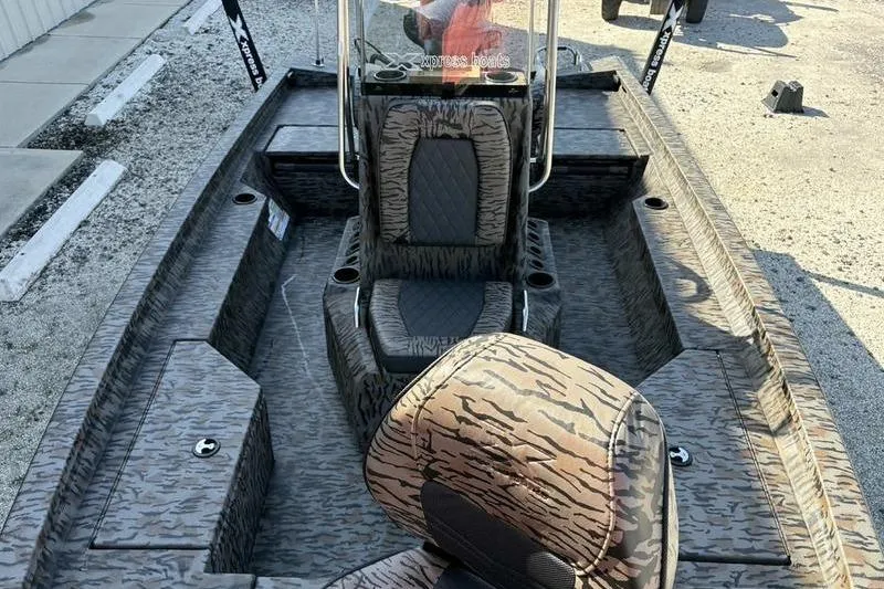 Slide: The Image of 2026 Xpress H20B Bay boat interior with camouflage seating and console. - 6