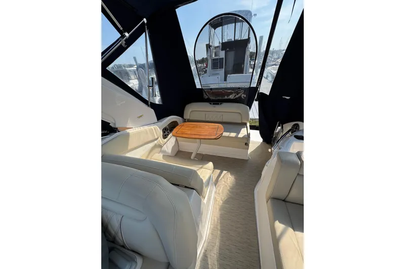 Slide: The Image of 2018 Regal 28 Express boat interior with seating and wooden table, featuring a covered cockpit. - 10