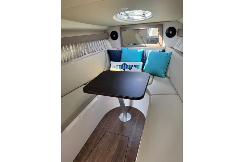 Slide: The Image of 2018 Regal 28 Express cabin interior with seating, table, and colorful cushions. - 12