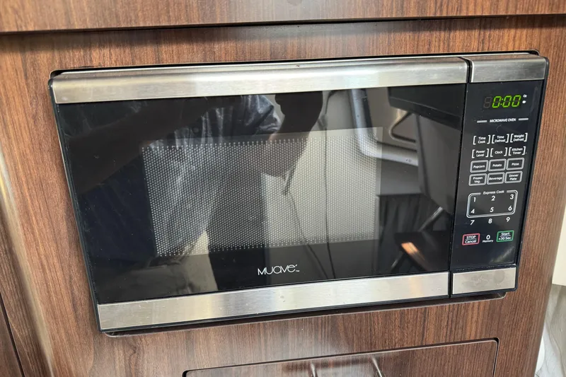 Slide: The Image of Microwave oven in 2018 Regal 28 Express boat interior, wood paneling background. - 17