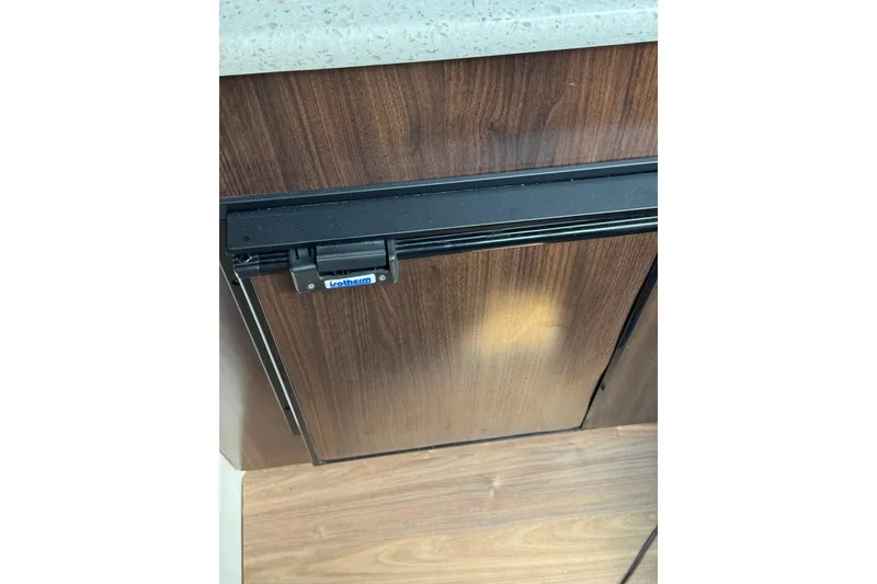 Slide: The Image of Wood-paneled refrigerator in 2018 Regal 28 Express boat interior. - 18