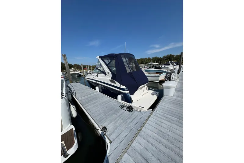 Slide: The Image of 2018 Regal 28 Express boat docked at marina under clear blue sky. - 2