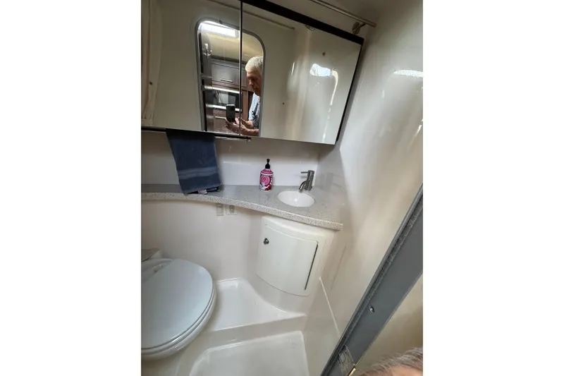 Slide: The Image of 2018 Regal 28 Express boat bathroom with sink, mirror, and toilet. - 22