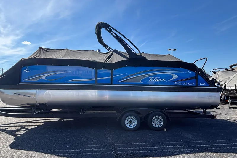 Slide: The Image of 2026 JC Neptoon 25TT Sport pontoon boat on trailer, covered, under clear blue sky. - 5