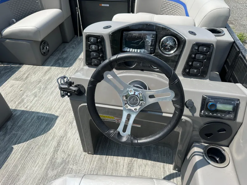Slide: The Image of 2023 Qwest 816 Lanai LT boat dashboard with steering wheel and control panel. - 2