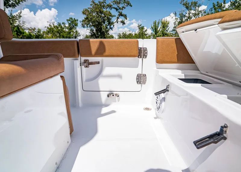 Slide: The Image of 2026 Sea Hunt Ultra 239 boat interior with brown seating and storage compartments. - 11
