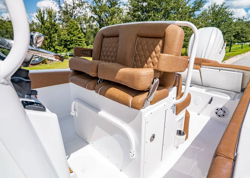 Slide: The Image of 2026 Sea Hunt Ultra 239 boat interior with brown cushioned seating and steering console. - 15