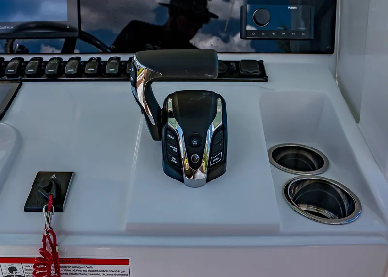Slide: The Image of Control panel of 2026 Sea Hunt Ultra 239 boat with throttle and cup holders. - 17