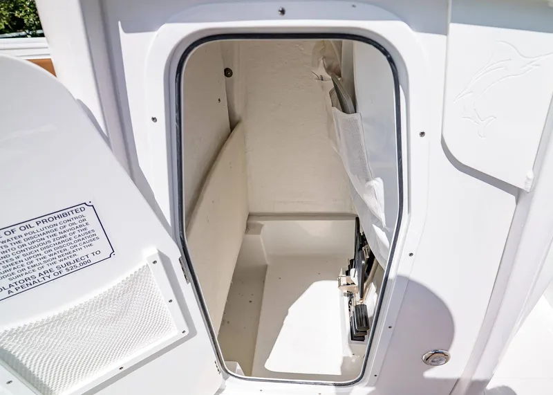Slide: The Image of 2026 Sea Hunt Ultra 239 storage compartment with open hatch, showcasing interior space. - 18