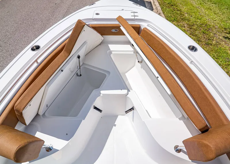 Slide: The Image of 2026 Sea Hunt Ultra 239 boat interior with brown seating and storage compartments. - 22
