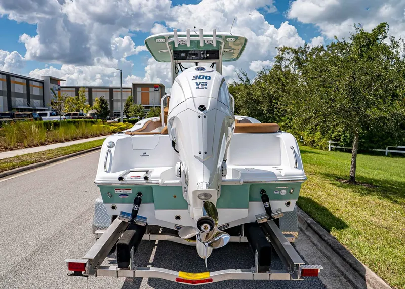 Slide: The Image of 2026 Sea Hunt Ultra 239 boat on trailer, parked on a sunny street. - 4