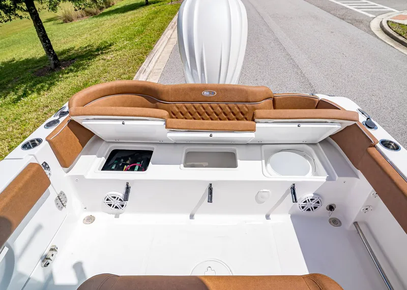 Slide: The Image of 2026 Sea Hunt Ultra 239 boat interior with brown seating and storage compartments. - 9