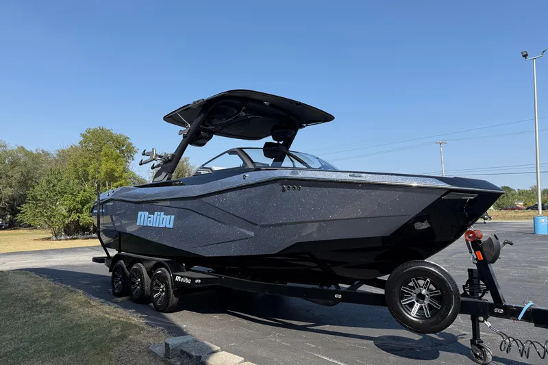 Slide: The Image of 2026 Malibu Wakesetter 26 LSV boat on trailer, parked outdoors under clear blue sky. - 3