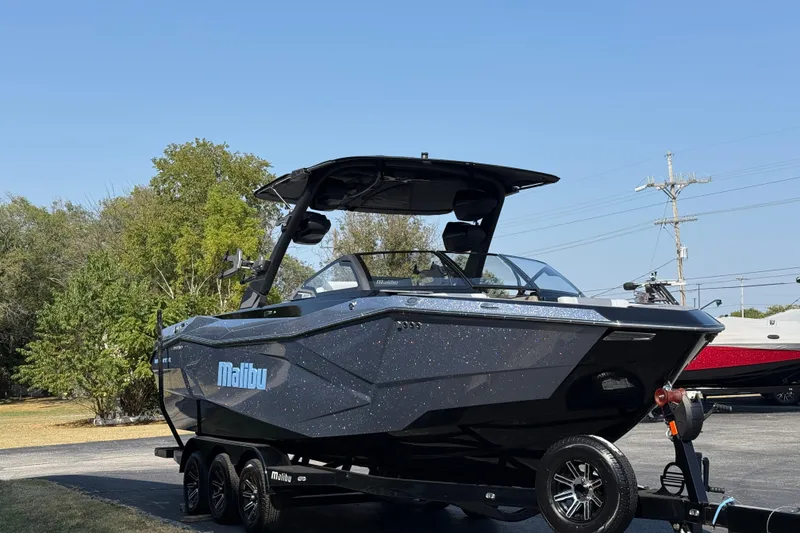Slide: The Image of 2026 Malibu Wakesetter 26 LSV boat on trailer, sleek design, parked outdoors. - 9